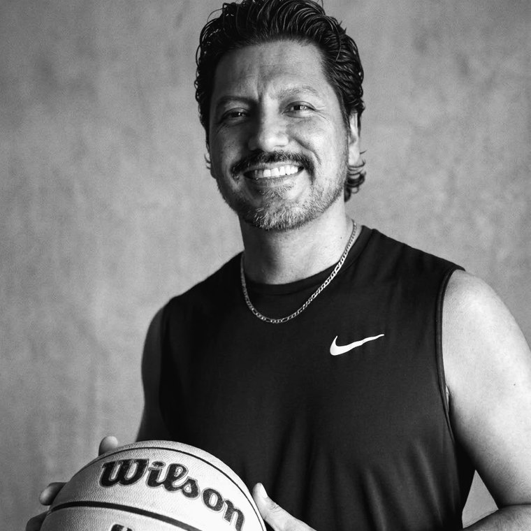 Heriberto sosteniendo un balón de basketball