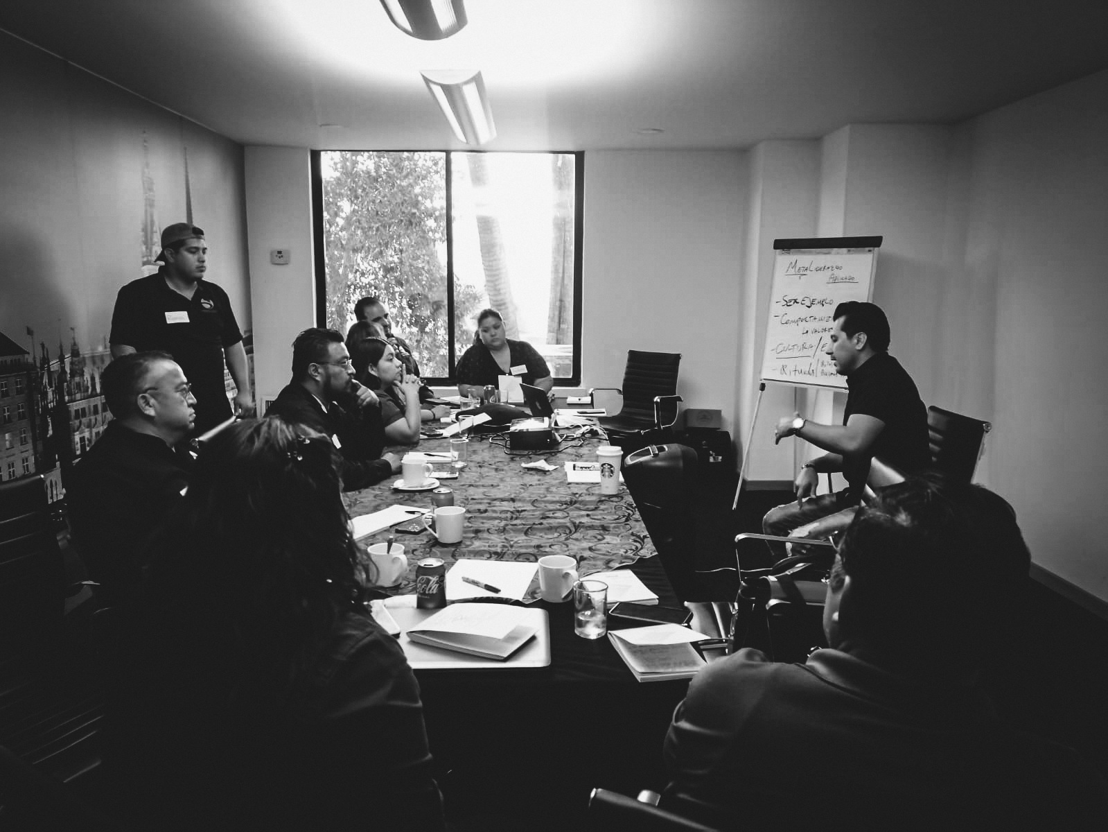 Heriberto durante una conversación de trabajo con un equipo en sala de reuniones